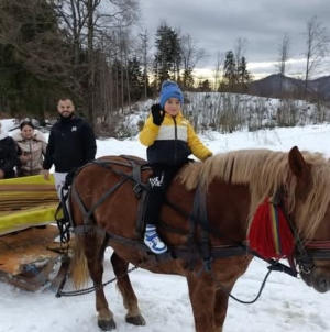 Turiști fericiți după o plimbare cu sania, trasă de iapa Karina